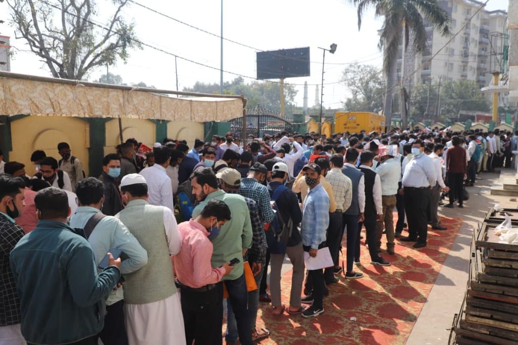 Large outdoor crowd queued for a community registration and outreach drive